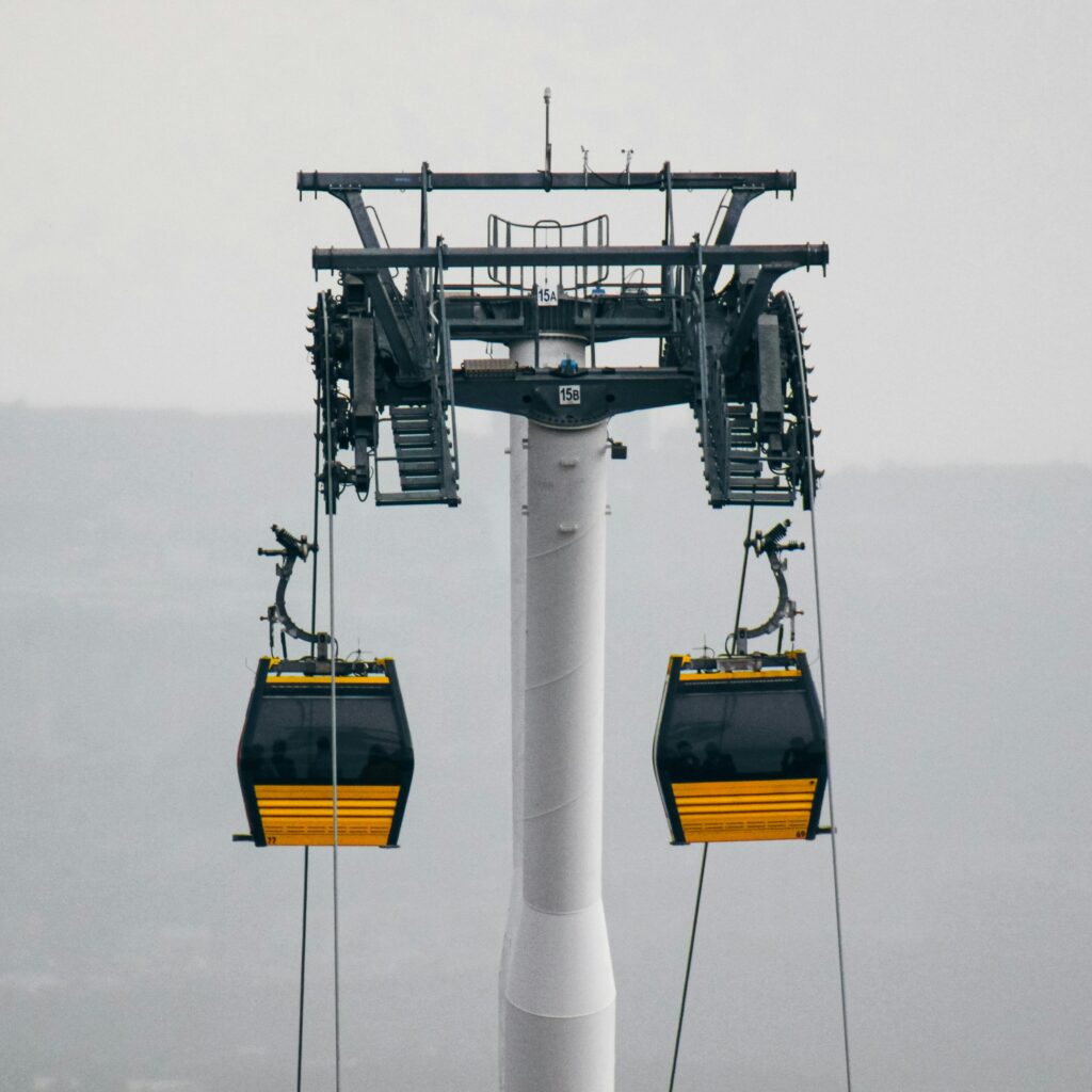 A cable car system with gondolas in a foggy outdoor setting, showcasing industrial design.
